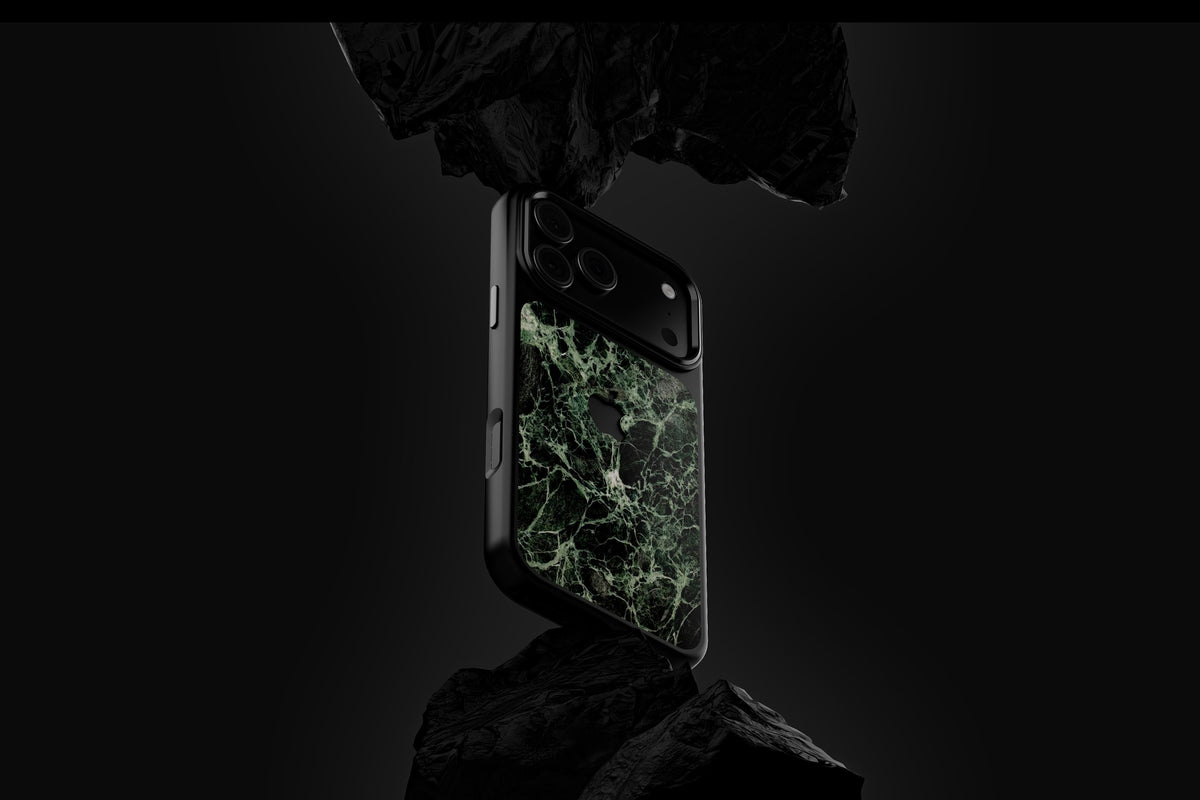 Marble Case Pro Verde Alpi mit schwarzem Rahmen zwischen dunklen Felsbrocken