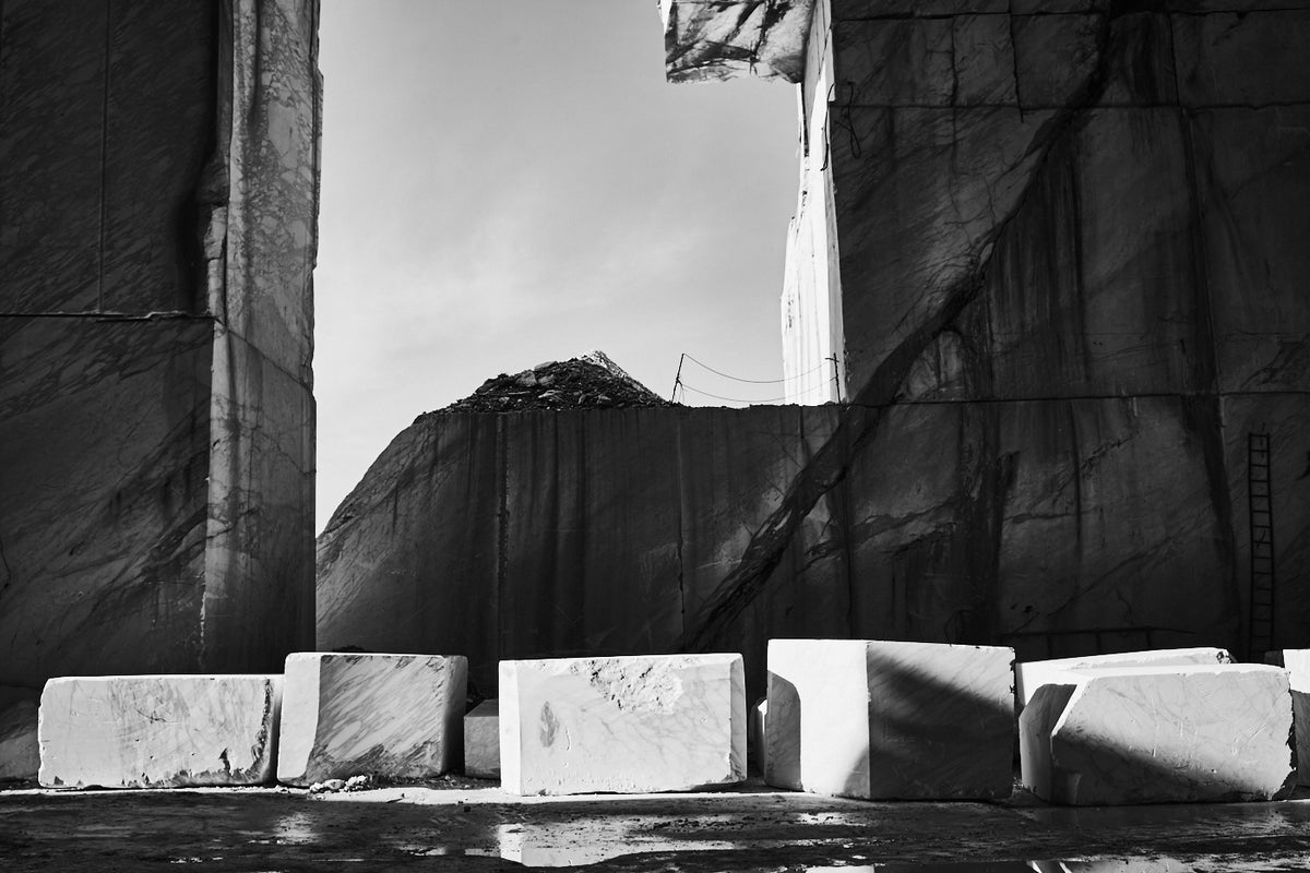 Cantera de mármol en blanco y negro con bloques cortados ante el frente de extracción