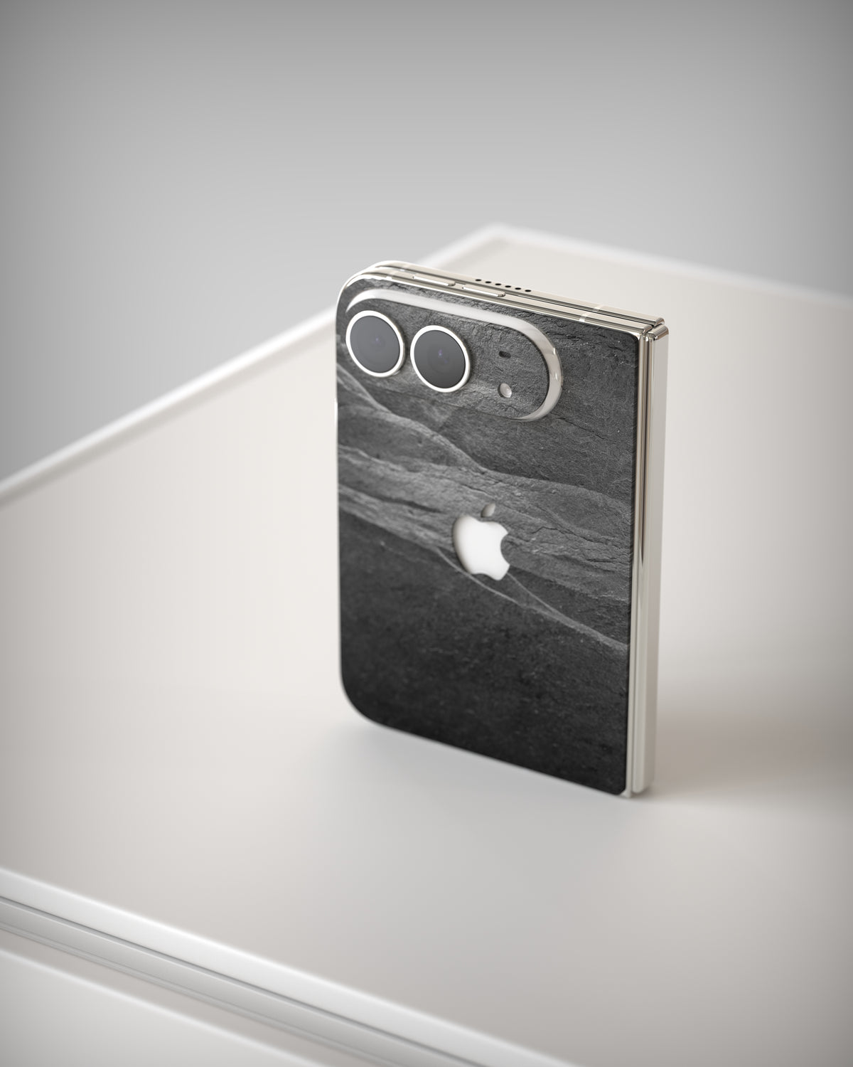 Slate Skin Black Rock on the iPhone Duo, angled from above – camera plateau and hinge edge