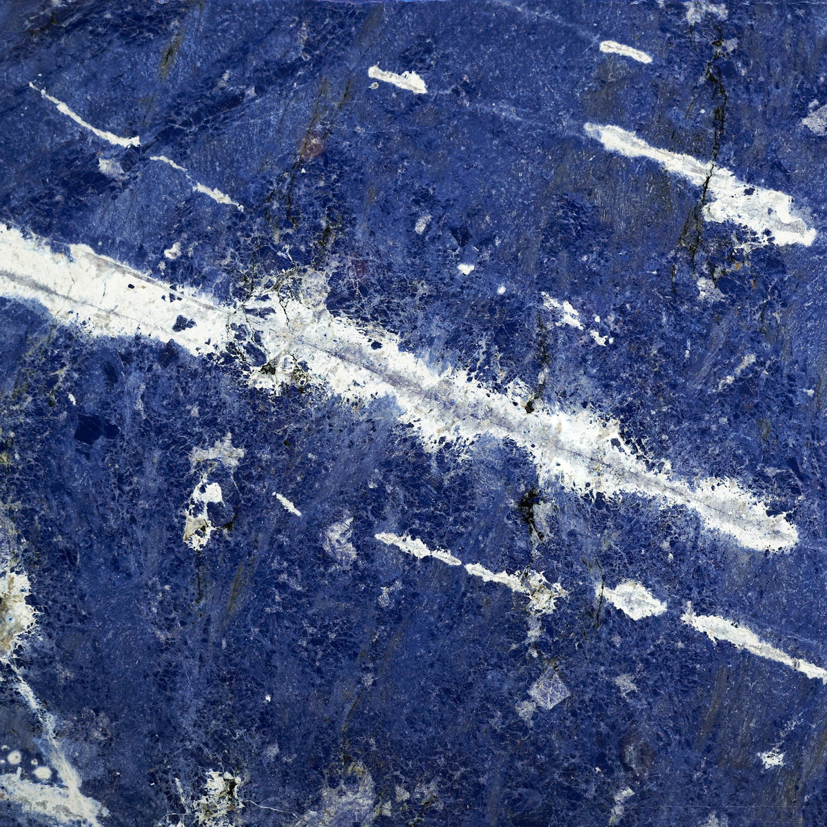 Lapislazuli: polierte, tiefblaue Steinfläche mit weißen Calcit-Adern